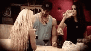 a man and two women are drinking wine at a table .
