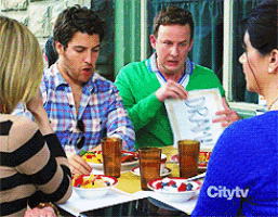 a group of people are sitting at a table with a city tv logo on the sleeve