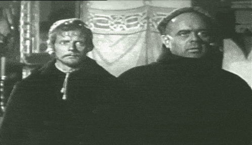 two men are standing next to each other and one has glasses on