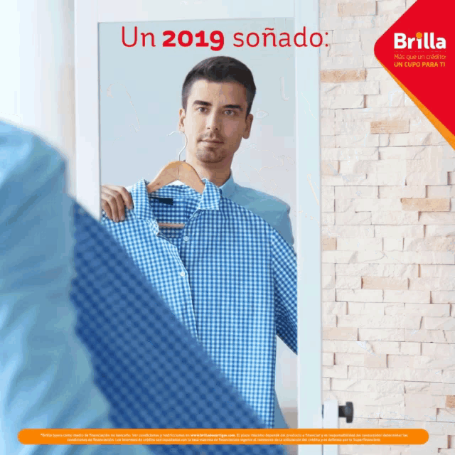 a man is holding a blue shirt in front of a mirror with the words un 2019 soñado on it