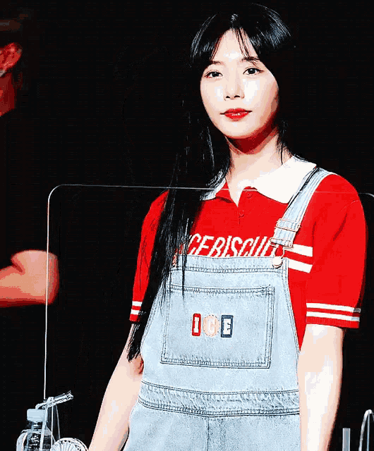 a girl wearing overalls and a red shirt that says icebiscuit
