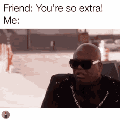 a bald man wearing sunglasses and a suit is sitting on a sidewalk and talking to a friend .