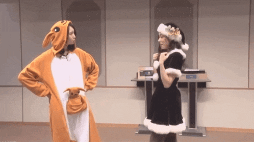 a woman in a kangaroo costume and a woman in a santa hat are standing next to each other