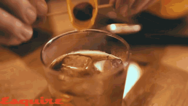 a close up of a drink with the word esquire in red on the bottom