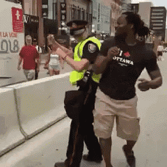 a man wearing a t-shirt that says i love ottawa stands next to a police officer