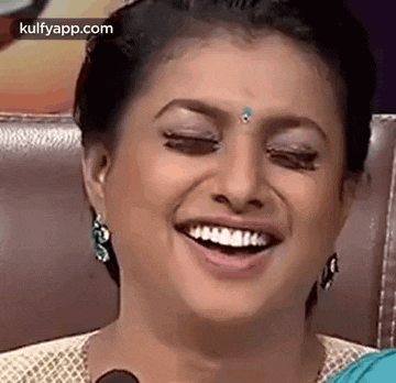 a close up of a woman 's face with her eyes closed and a smile on her face .