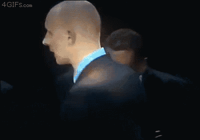 a bald man in a suit and blue shirt is standing next to a black man in a suit