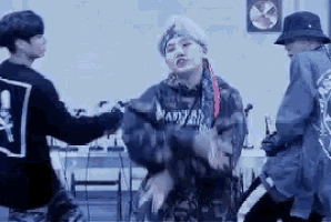 a group of young men are standing next to each other dancing in a room .
