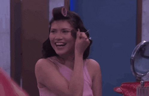 a woman with curlers in her hair is applying makeup to her face