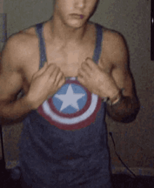 a man wearing a tank top with a captain america emblem on it