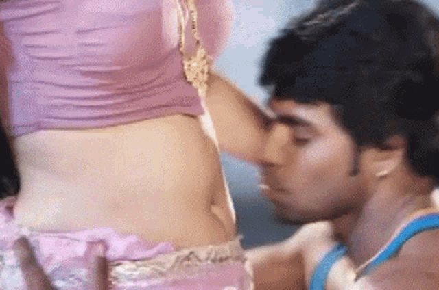 a man is kissing a woman 's stomach in a close up .