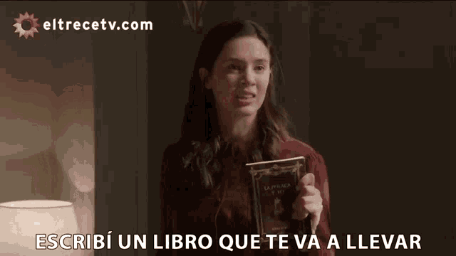 a woman holding a book that says " a la fam " on it