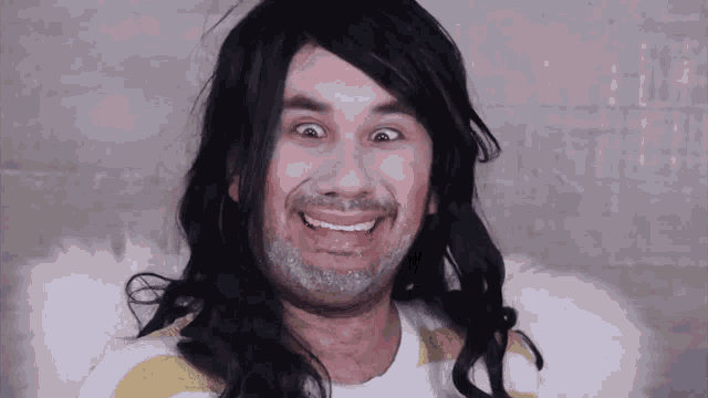 a man with long hair and a beard is wearing a wig and making a funny face