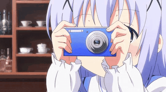 a girl taking a picture with a blue camera that says ' nikon ' on it