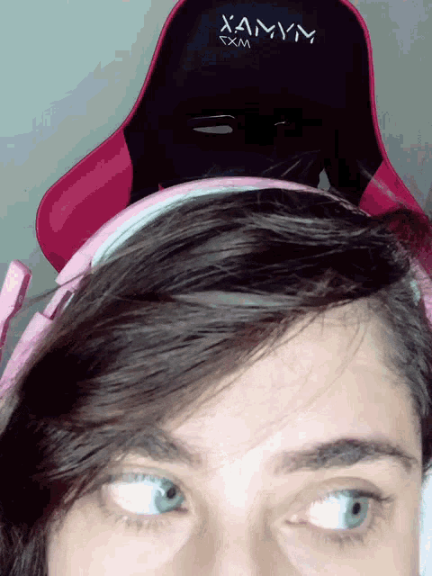 a woman wearing headphones and a chair that says xamym