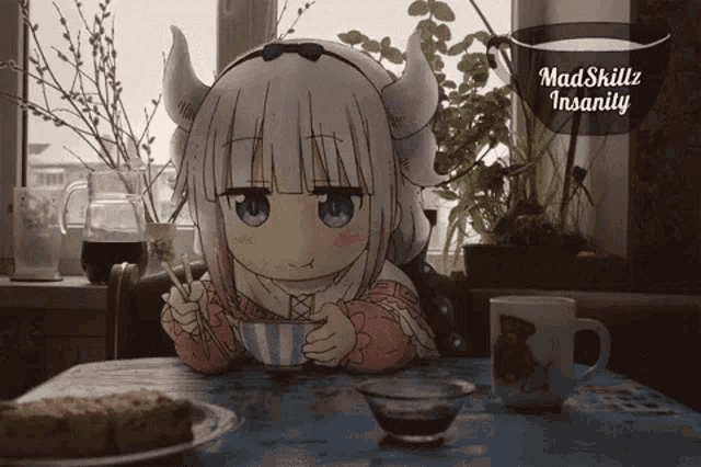 a little girl with horns is sitting at a table drinking from a cup