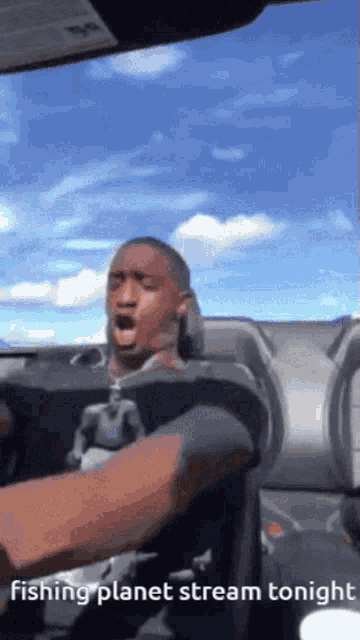 a man driving a car with the words fishing planet stream tonight