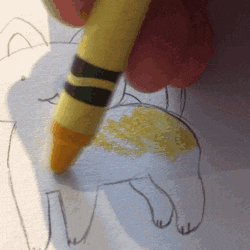 a yellow crayon is being used to draw a cat on a piece of paper