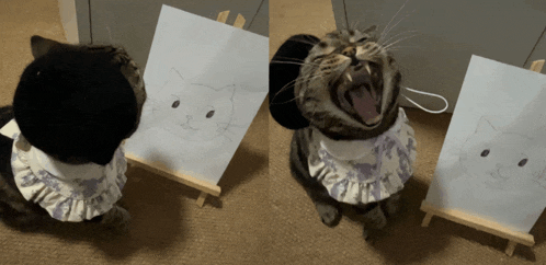 a cat wearing a bib yawning next to a drawing of a cat