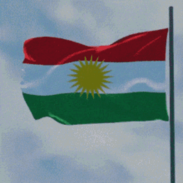 a red white and green flag with a yellow sun in the middle