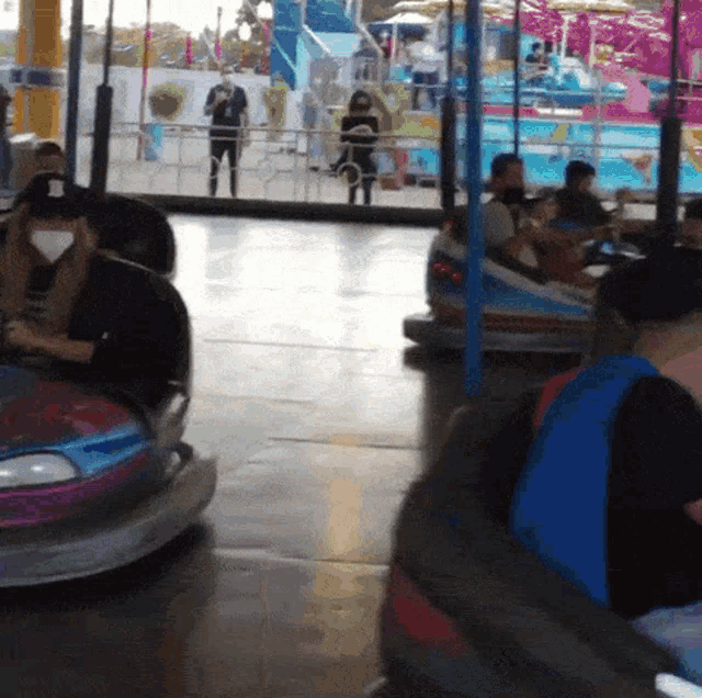 a group of people are riding bumper cars at a carnival
