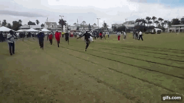 a group of people are running on a track in a field