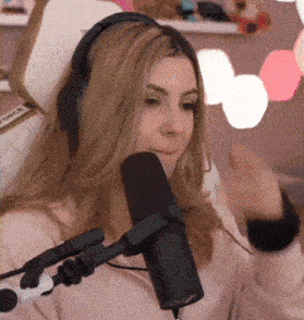 a woman wearing headphones is sitting in front of a microphone that says force on it