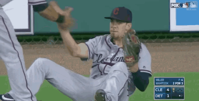 a baseball player in a cleveland uniform is laying on the field