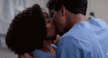 a man and a woman are kissing in a hospital room