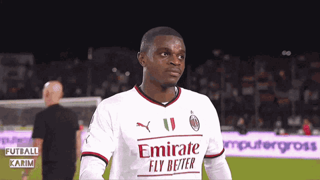a soccer player wearing a white emirates fly better shirt