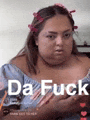 a woman with a flower in her hair is wearing a blue off the shoulder top with the words `` da fuck '' written on it .