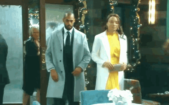 a man and woman are standing next to each other in a room .