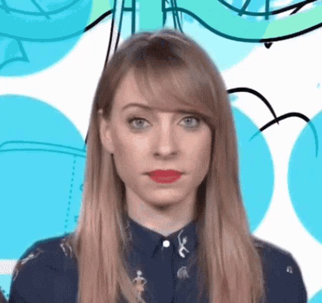 a woman with long blonde hair and red lips is making a funny face .