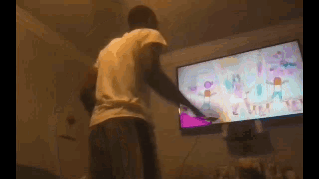 a man is playing a video game on a flat screen tv