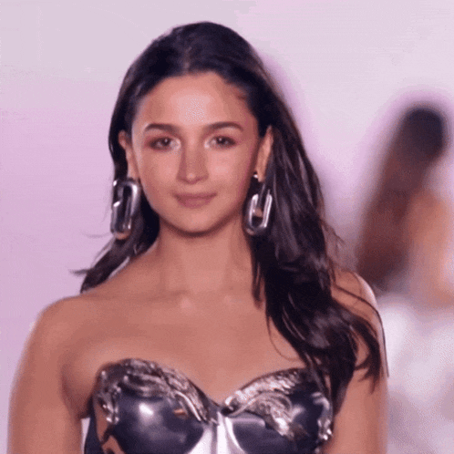 a close up of a woman wearing a strapless top and hoop earrings