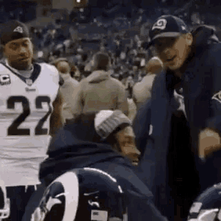 a football player with the number 22 on his jersey is talking to a coach .