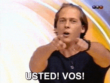 a man is pointing at the camera with the words usted vos behind him