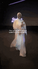a blurred image of a person standing in a dark room with a green light behind them .