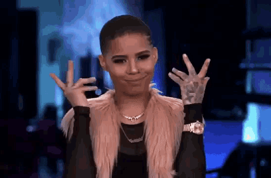 a woman is making a peace sign with her hands .
