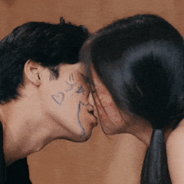 a man and a woman are kissing with hearts and stars drawn on their faces