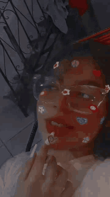 a girl wearing glasses with stickers on her face