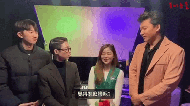a group of people are standing in front of a screen with chinese writing
