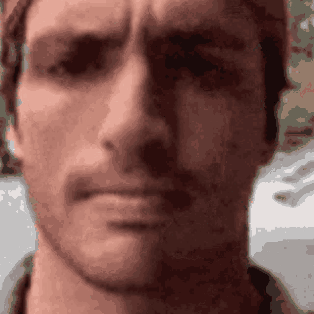 a close up of a man 's face wearing a hat