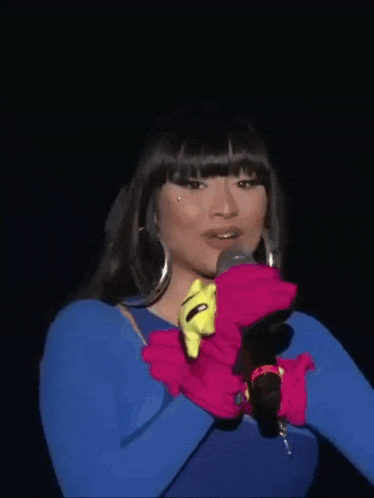 a woman in a blue dress and gloves is smiling with her arms crossed