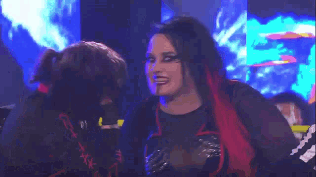 a woman with red hair is standing next to a man in a dark room .