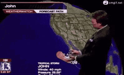 a man in a suit and tie is standing in front of a map of the world .