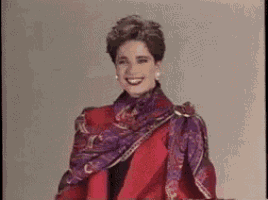 a woman is wearing a red coat and a purple scarf .