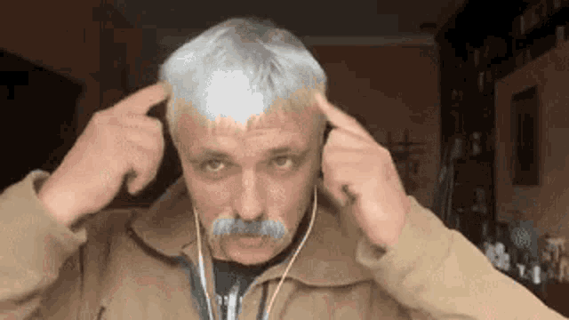 a man with a mustache is wearing headphones .