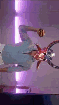 a man in a blue shirt is wearing a devil mask