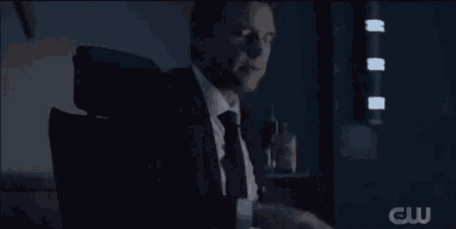 a man in a suit and tie is sitting in a chair and says `` what 'd ya bring me ? ''